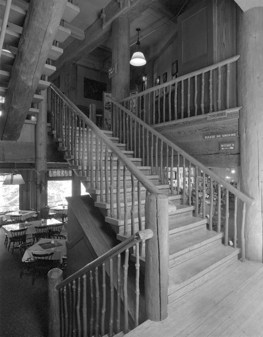 The grand stair as viewed between the third floor dining room and lobby on the fourth floor. Pine logs were used for stringers. The steps are oak and the balustrade is madrone with lodgepole pine railings.